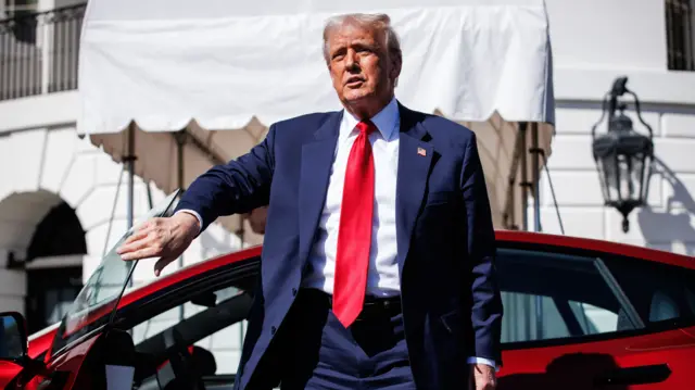 US President Donald Trump climbs out of a Tesla Model S on the South Lawn of the White House in Washington, D.C