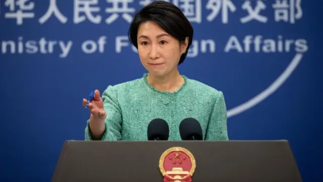 China's foreign ministry spokesperson Mao Ning speaks wearing a green jacket behind a podium.