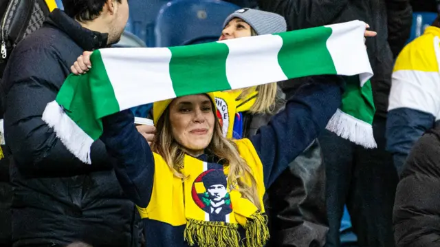 Fenerbahce fan holds up green and white scarf