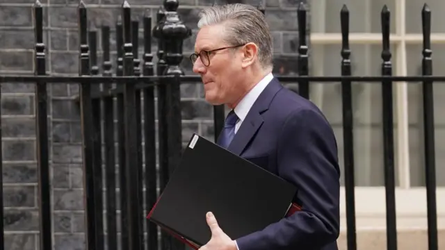 Keir Starmer walking with folders in his hand