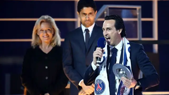 Paris Saint-Germain head coach Unai Emery is watched by Paris Saint-Germain's Qatari president Nasser Al-Khelaïfi as he speaks on the podium after winning the French Ligue 1 title