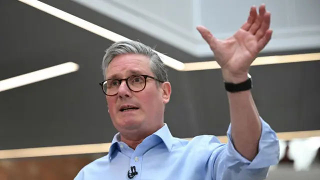 Keir Starmer raises a hand over his head as he speaks at a Q&A in Hull.