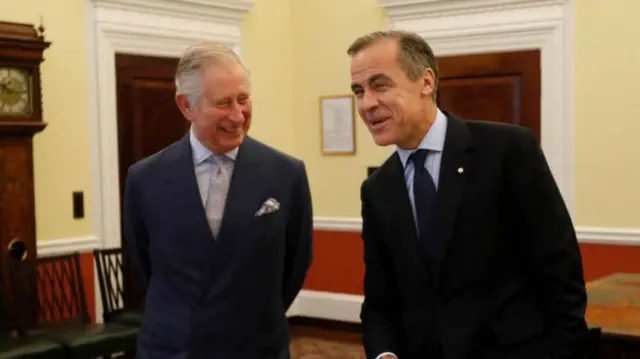 King Charles and Mark Carney in a room with yellow walls.