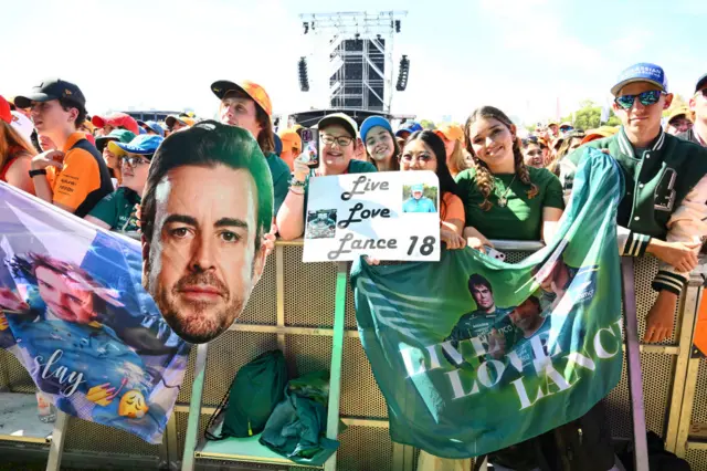 Fans hold up Fernando Alonso signs