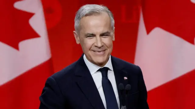 Mark Canrey in front of a large Canadian flag