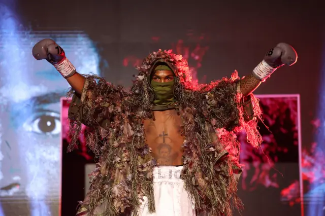 Jadier Herrera wearing a camouflage robe as he walks to the ring to face Jose Enriquez