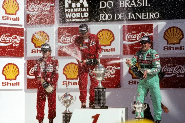 Nigel Mansell, Alain Prost and Mauricio Gugelmin spray champagne on the podium after the 1989 Brazilian Grand Prix