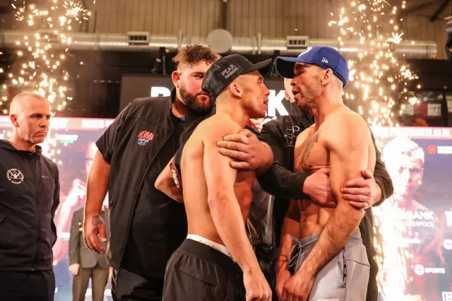 Nick Ball and TJ Doheny are held apart by security on a stage at a weigh-in