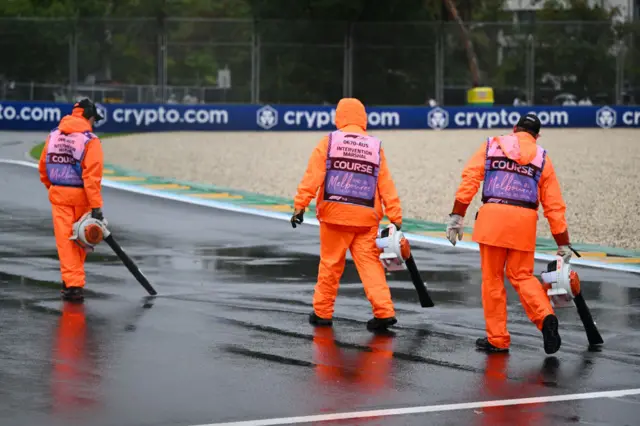 Marshals attempt to dry the track