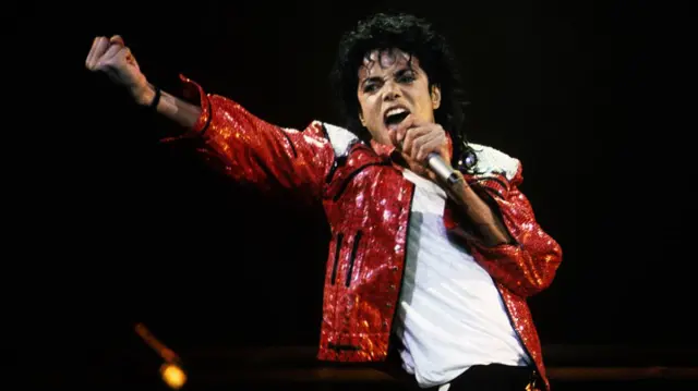 Michael Jackson performing in a red jacket