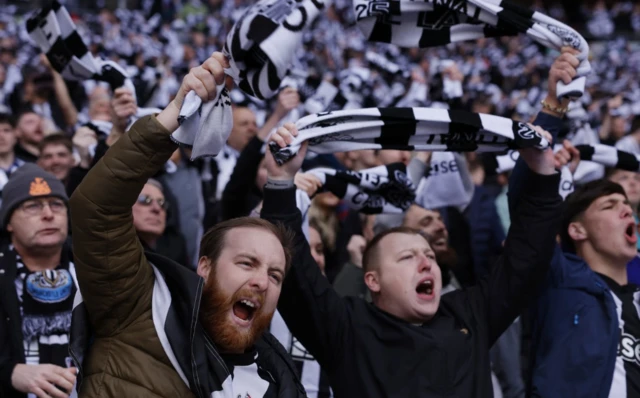 Newcastle United fans holding scarves up