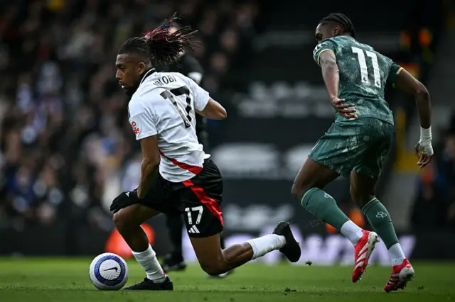 Alex Iwobi (L) fights for the ball with Tottenham Hotspur's French striker Mathys Tel