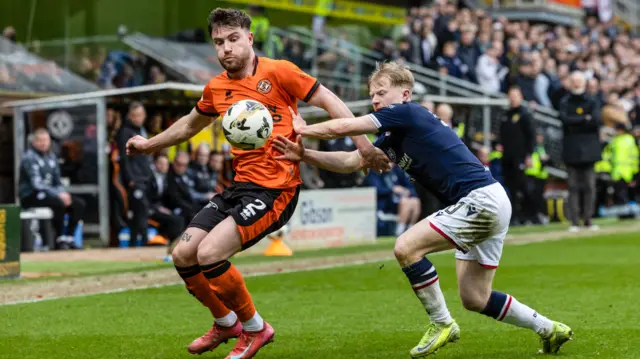 Dundee United's Ryan Strain with Dundee's Lyall Cameron