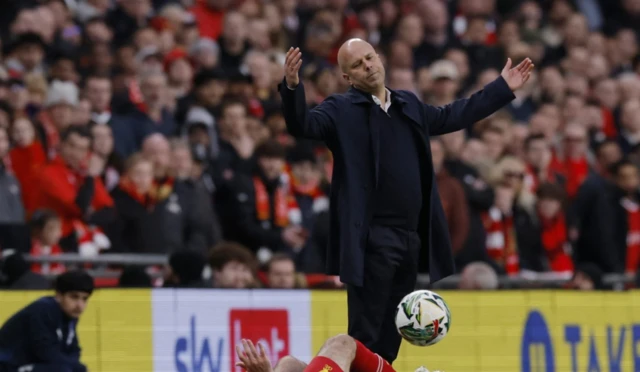 Liverpool's Dominik Szoboszlai in action with Newcastle United's Bruno Guimaraes as Liverpool manager Arne Slot reacts