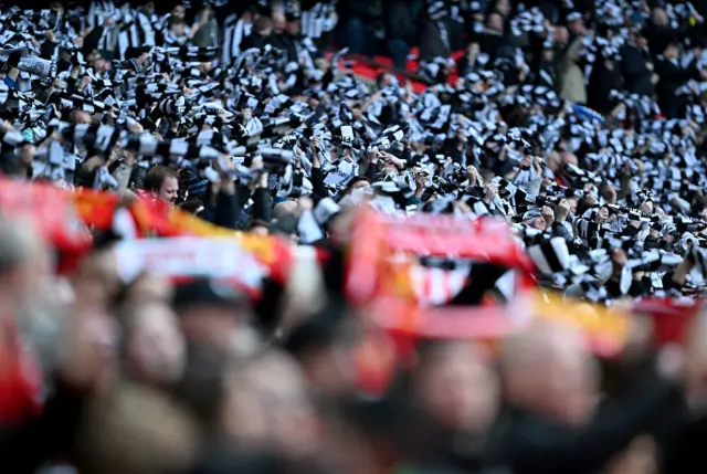 Fans of Newcastle United hold up scarfs