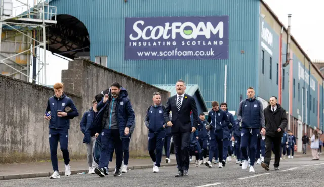 Tony Docherty, suited and booted, leads his side down Tannadice Street