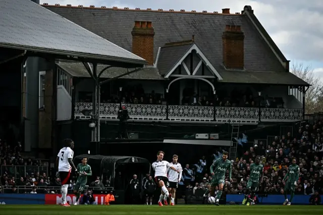 Sander Berge (C) controls the ball with the original Craven Cottage building in the background