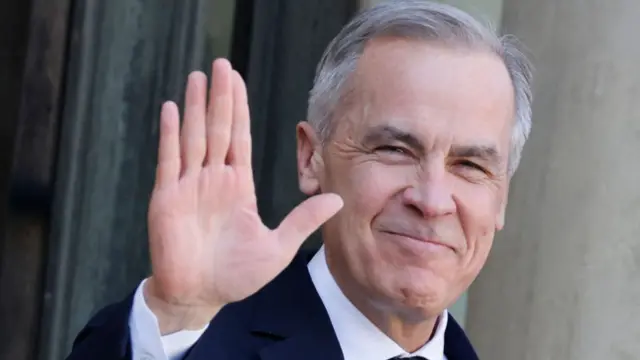 Mark Carney waving at a camera