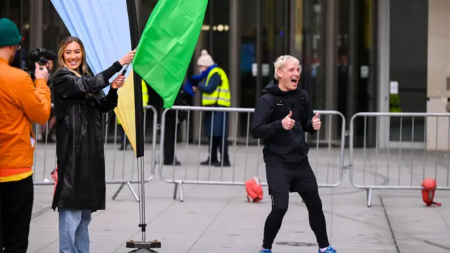 Jamie Laing at the starting line with Sophie Habboo waving a green flag