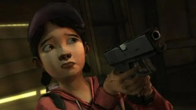 Cartoon character Clementine wears a pink hoodie and grips a gun while looking concerned.