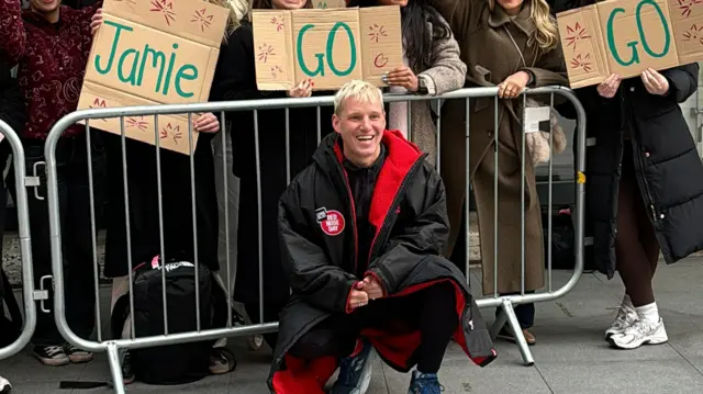 Jamie flanked by signs of support