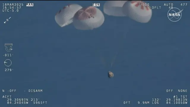 Four parachutes above the dragon capsule in a blue sky