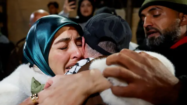 A woman embraces a man, crying