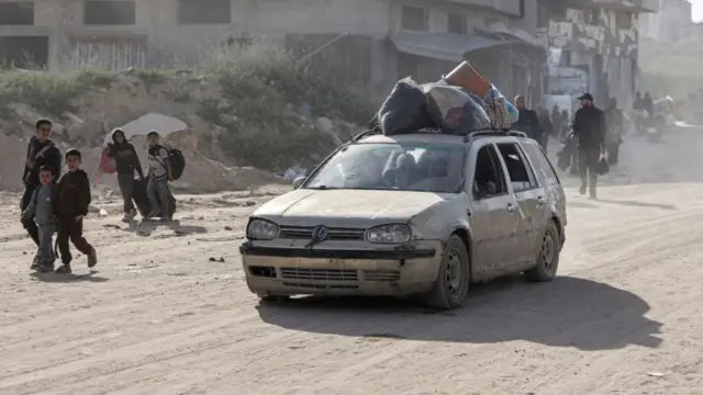 Car laden with belongings on dusty road