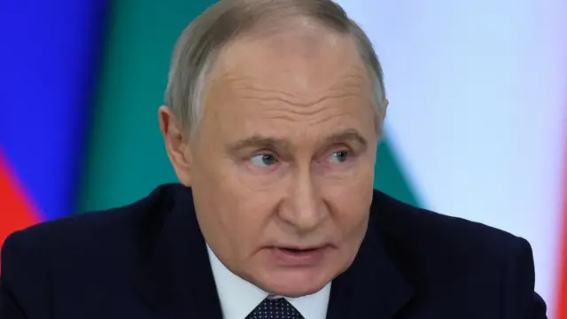 A close up of Putin's face - he looks to the right