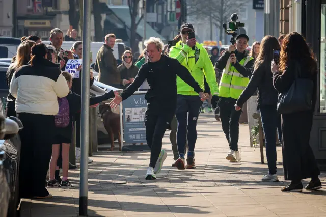 Jamie Laing high fives crowds on Day 3 of his ultra marathon challenge for Comic Relief