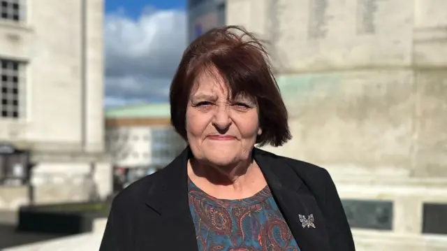 Hazel Simmons standing in front of Luton Town Hall on a sunny day