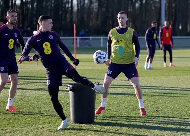 Adam Wharton of England looks on as teammate Phil Foden controls the ball