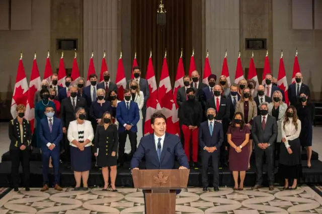 Justin Trudeau stands in front of his cabinet, all who