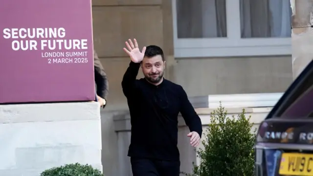 Zelensky in black outfit waving.