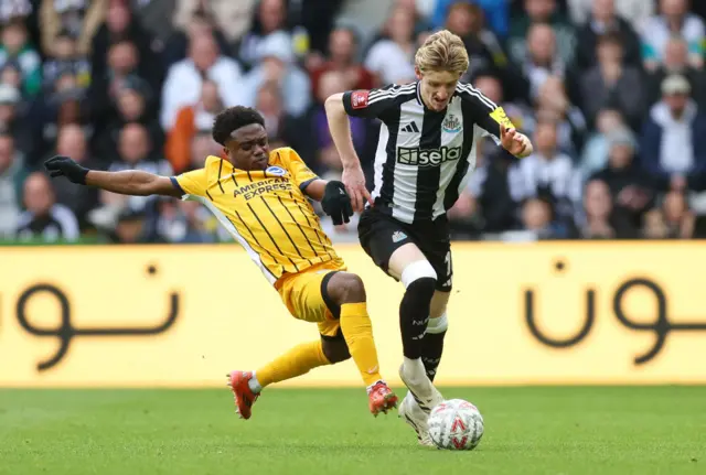 Anthony Gordon of Newcastle United is challenged by Tariq Lamptey