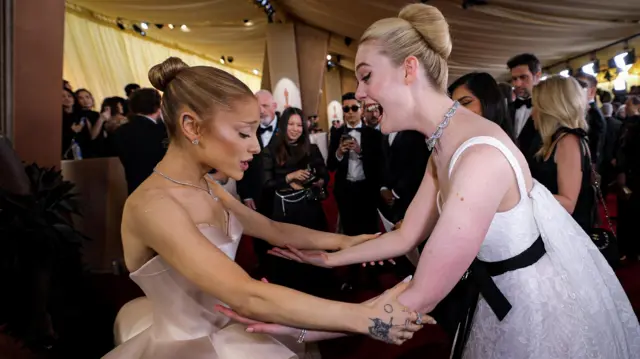 Elle Fanning greets Ariana Grande on the red carpet d