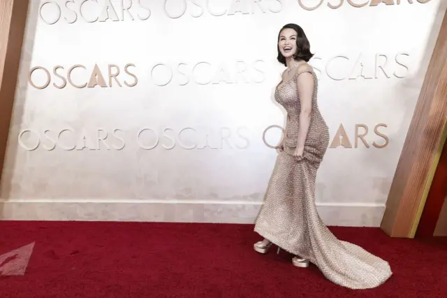 Selena Gomez wearing a champagne studded dress on the Oscars red carpet