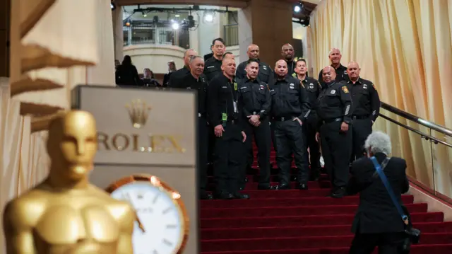 Firefighters pose on the red carpet during the Oscars arrivals