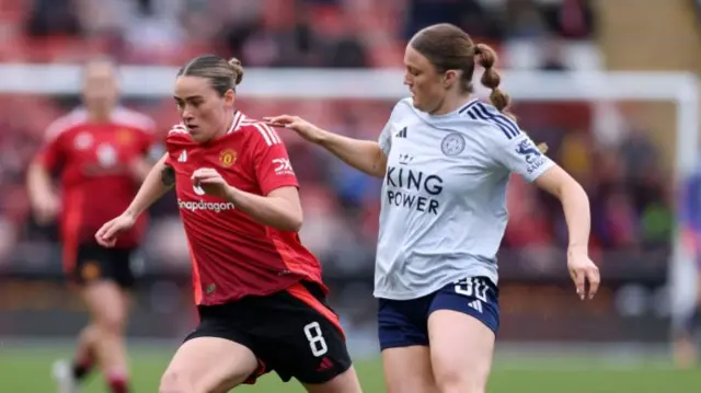 Man United's Grace Clinton and Leicester's Ruby Mace battle for the ball.