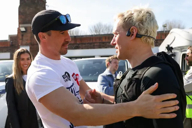 JP giving Jamie Laing a hug, with Sophie Habboo smiling in the background