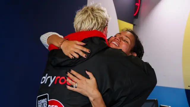 Jamie hugs Vick Hope, he's wearing a dry robe