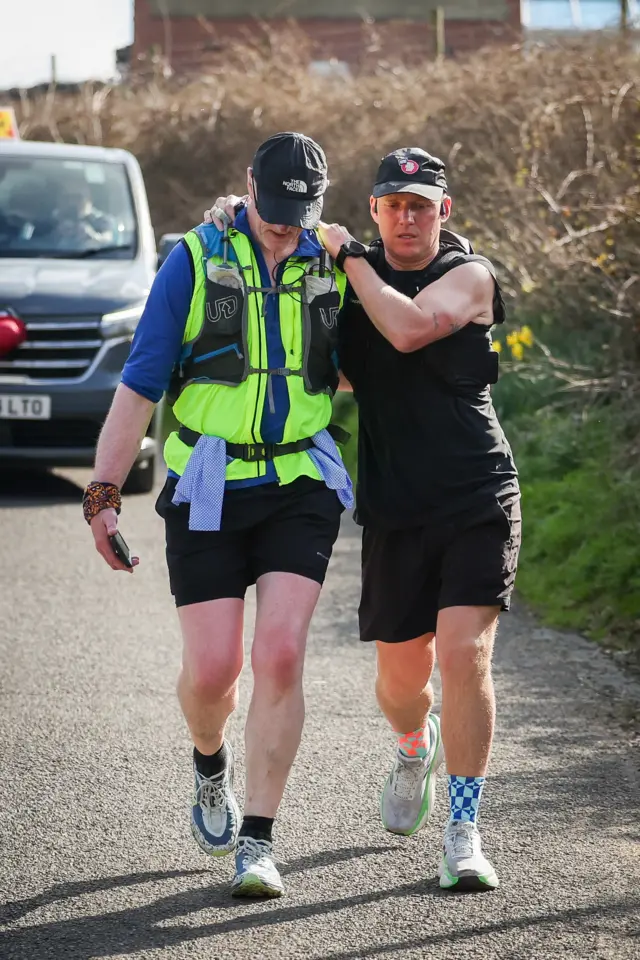 Jamie is supported by one of his team on the road.