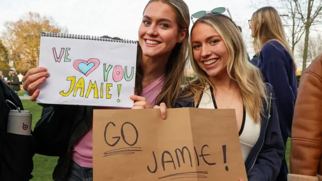 Two of Jamie's supporters hold signs to show their support