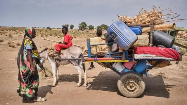 A Sudanese family newly arrived in South Sudan carrying all their belongings