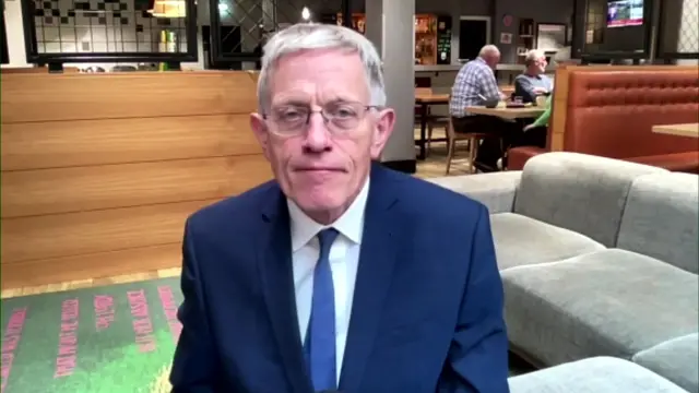 Travel Journalist Simon Calder  sat in a suit and tie in a cafe