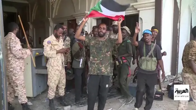 Soldiers stand at the palace, one waves a flag.