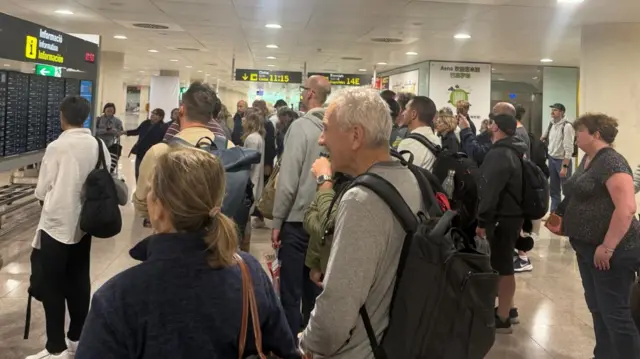 Passengers queue at airport