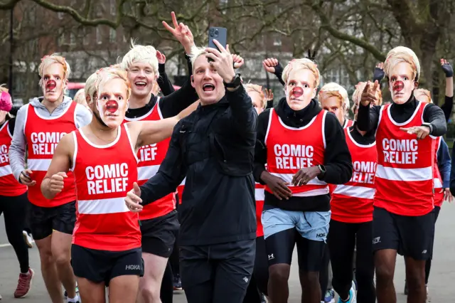 Jamie Laing being followed by a group of people dressed as Jamie Laing.
