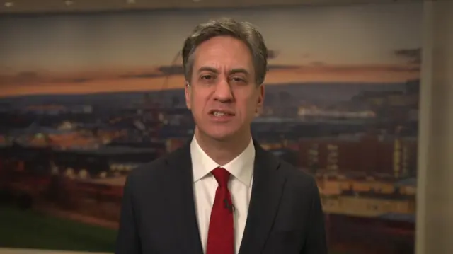 Ed Miliband speaks to BBC Breakfast, he is wearing a suit with a red tie