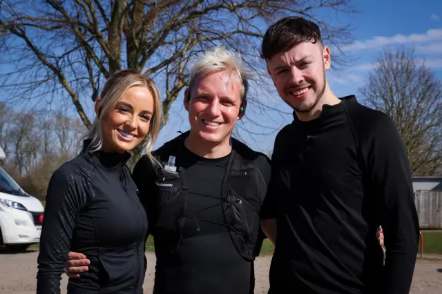 Jamie smiling and posing for a photo with Leanne and Jake from The Traitors